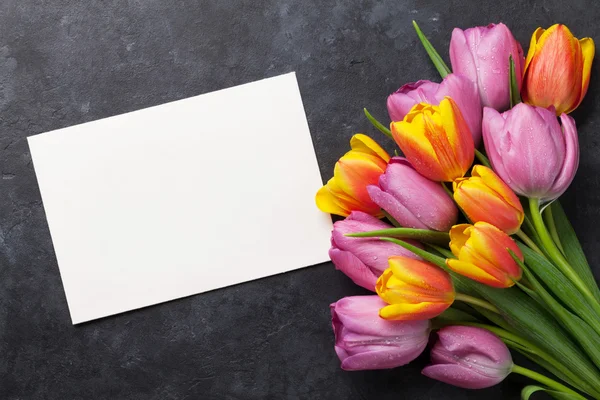 Tulipas frescas e cartão de felicitações — Fotografia de Stock