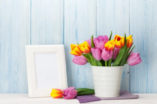 Fresh colorful tulips bouquet and photo frame — Stock Photo, Image