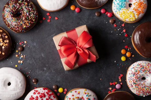 Красочные пончики и подарочная коробка — стоковое фото