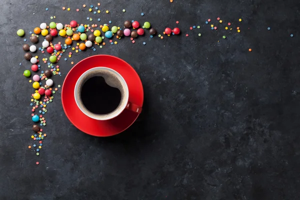 Coloridos caramelos y taza de café —  Fotos de Stock
