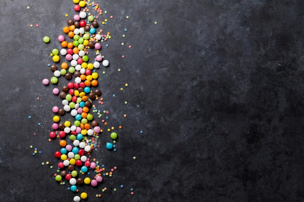 Taş arka plan üzerinde renkli şekerler — Stok fotoğraf