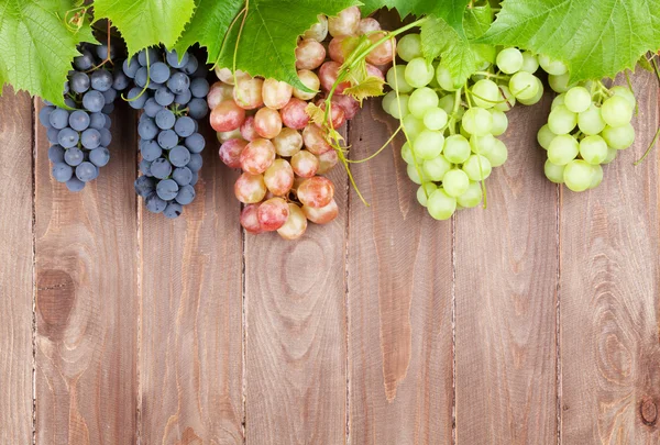 Kiść winogron na drewnianym stole — Zdjęcie stockowe