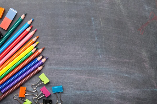 School supplies on blackboard — Stock Photo, Image