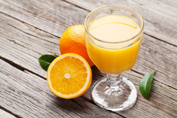 Naranjas y vaso de jugo — Foto de Stock
