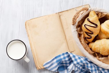 Taze kruvasanlar, süt ve eski kitap