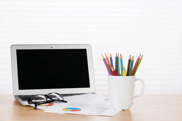 Office arbetsplatsen med laptop, rapporter och pennor — Stockfoto