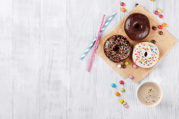 Donuts e café na mesa de madeira — Fotografia de Stock