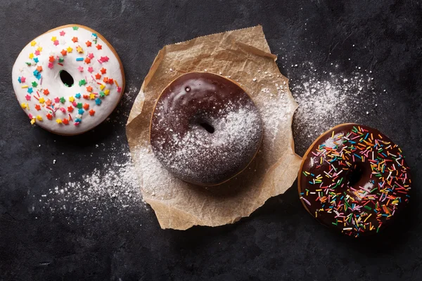 Donuts coloridos na mesa de pedra — Fotografia de Stock