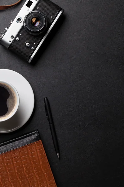 Schreibtisch mit Kamera, Kaffee und Notizblock — Stockfoto