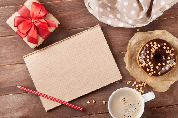 Bloco de notas, rosquinha e café na mesa — Fotografia de Stock