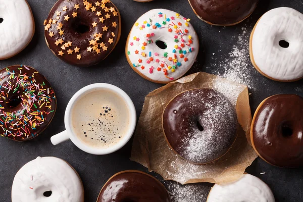 Donuts coloridos e xícara de café — Fotografia de Stock
