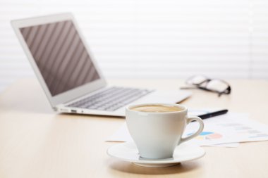 Dizüstü bilgisayar ve kahve ile ofis işyeri