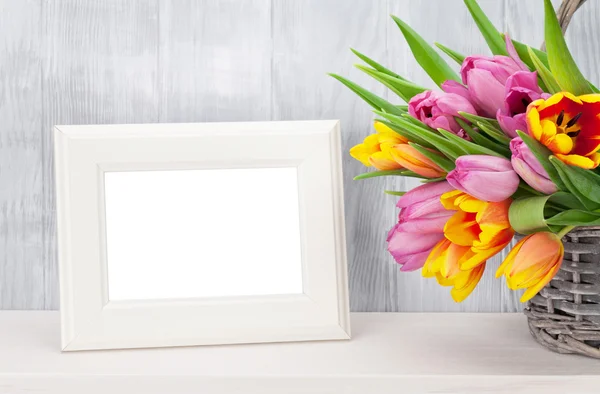 Fresh colorful tulips bouquet and photo frame — Stock Photo, Image