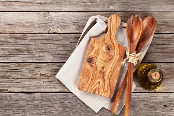 Utensilios de cocina y aceite de oliva sobre mesa de madera —  Fotos de Stock