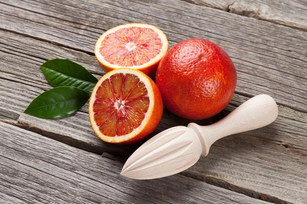 Fresh ripe red oranges and juicer — Stock Photo, Image