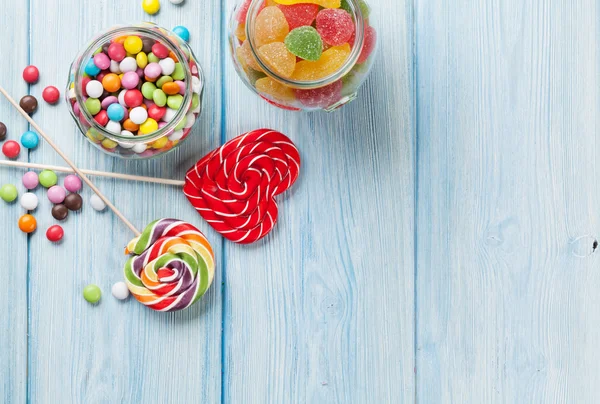 Doces coloridos na mesa de madeira — Fotografia de Stock