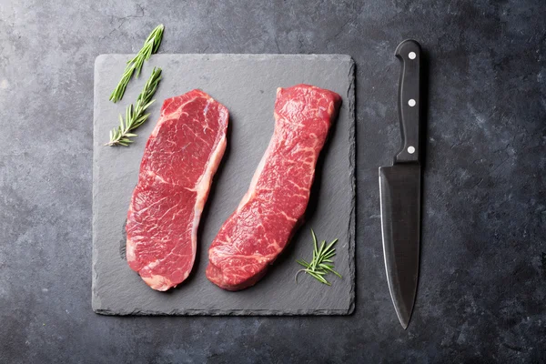 Bistecche di striploin crude con rosmarino — Foto Stock