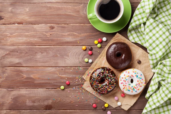 Donuts y café sobre mesa de madera — Foto de Stock