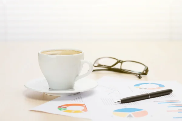 Büroarbeitsplatz mit Kaffee, Vorräten und Berichten — Stockfoto