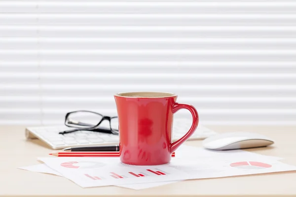 Escritório local de trabalho com café e gráficos — Fotografia de Stock