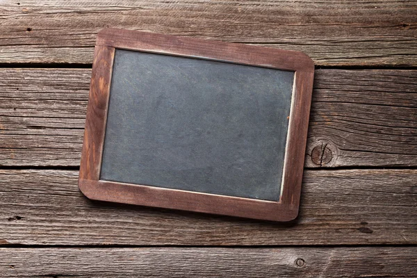 Blackboard on wooden table — Stock Photo, Image