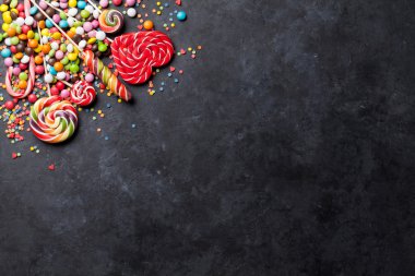 Renkli şekerler ve taş üzerinde lolipop