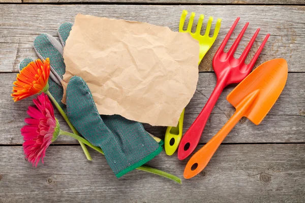 Gardening tools, glove and gerbera flowers — Stock Photo, Image