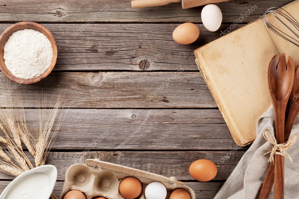 Kitchen table with cookbook, utensils and ingredients — Stock Photo