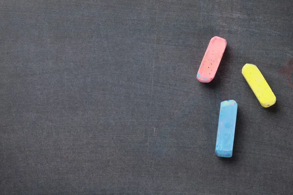 Kleurrijke krijtjes op blackboard achtergrond — Stockfoto