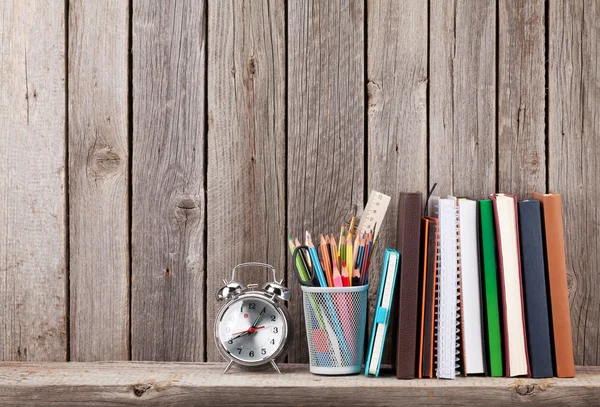 Houten plank met boeken en supplies — Stockfoto