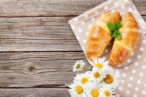 Fresh croissants and chamomile flowers — Stock Photo, Image