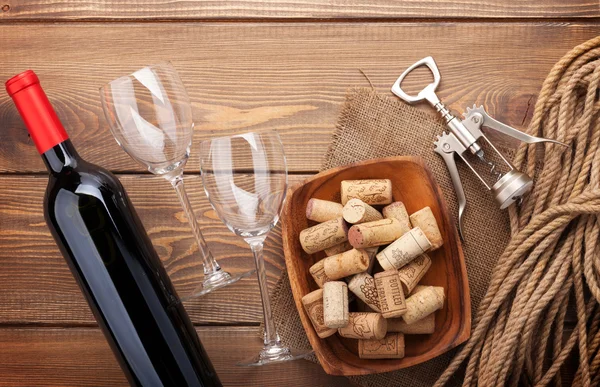Botella de vino tinto, copas de vino, tazón con corchos y sacacorchos — Foto de Stock