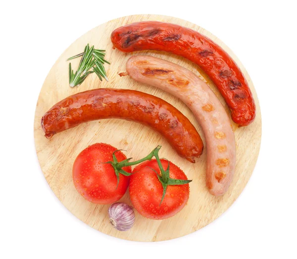 Various grilled sausages with condiments and tomatoes — Stock Photo, Image