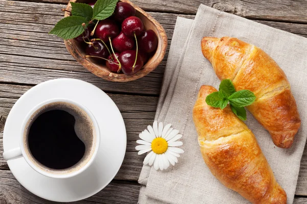 Croissants und Kaffeetasse auf Holztisch — Stockfoto