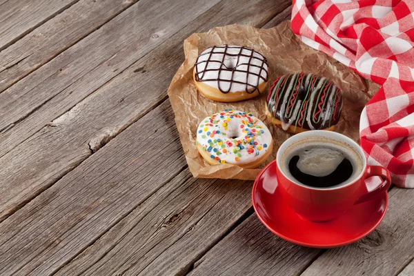 Donuts y café sobre mesa de madera — Foto de Stock
