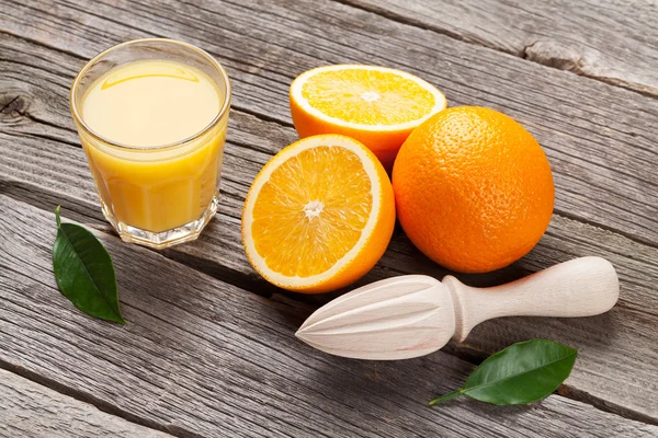 Färska mogna apelsiner och juice — Stockfoto