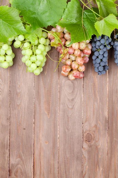 Ramo de uvas sobre mesa de madera —  Fotos de Stock