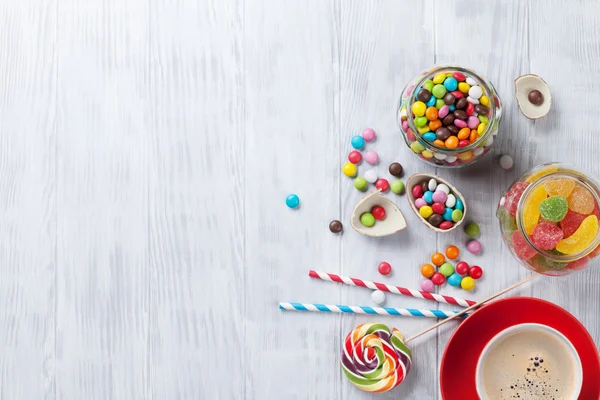 Coloridos caramelos y taza de café —  Fotos de Stock