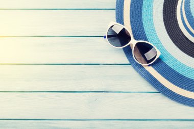 Şapka ve güneş gözlüğü ahşap arka plan üzerinde