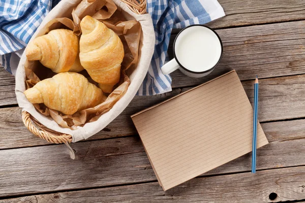 Fresh croissants and notepad — Stock Photo, Image