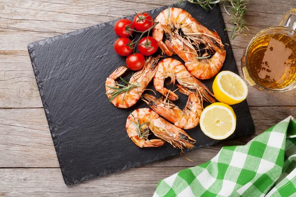 Gegrilde garnalen op stenen plaat en bier mok — Stockfoto