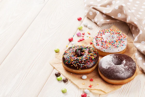 Пончики и конфеты на столе — стоковое фото