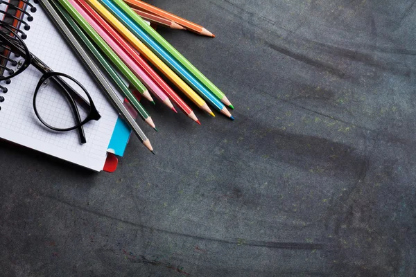 Notepads and supplies over chalk board — Stock Photo, Image