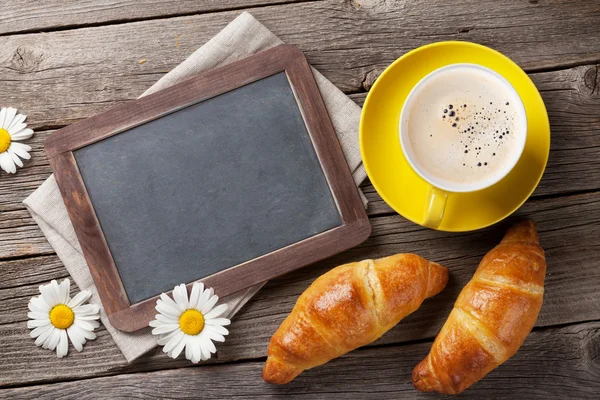 Blackboard, croissants, flowers and coffee — Stock Photo, Image
