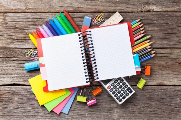 Bloco de notas sobre suprimentos coloridos na mesa — Fotografia de Stock