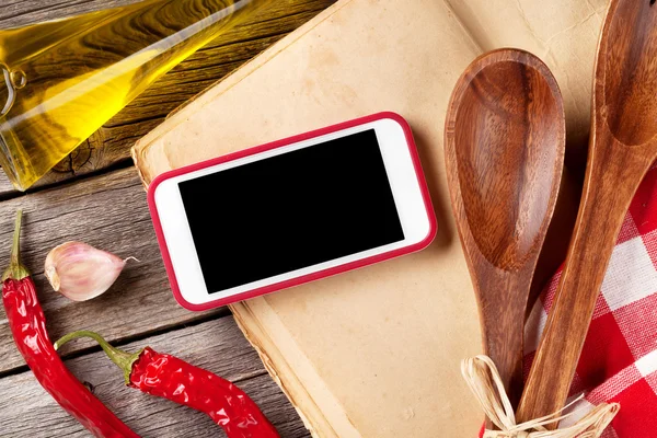 Keukentafel met keukengerei en telefoon — Stockfoto