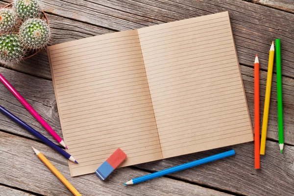 Notepad and colorful supplies over wood — Stock Photo, Image