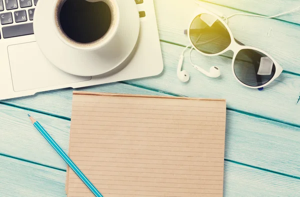 Scrivania con computer portatile, caffè e occhiali da sole — Foto Stock