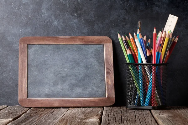 Supplies and chalk board — Stock Photo, Image