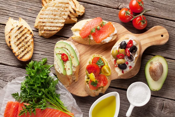 Sanduíches de torradas com abacate, tomates, salmão — Fotografia de Stock